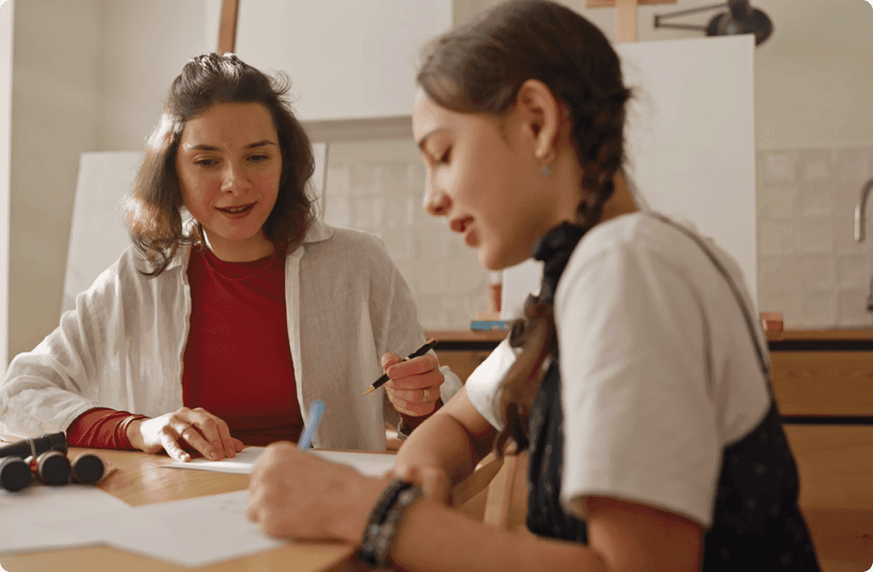 Teacher guiding student in creative activity.